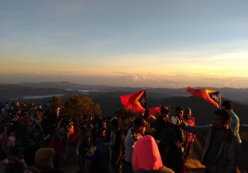 Foto no cume do Monte Ramelau, ponto mais alto de Timor-Leste, junto com vários timorenses e bandeiras do país
